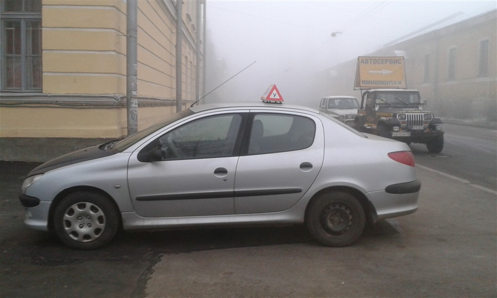 Серебристый учебный Peugeot 206, вид сбоку